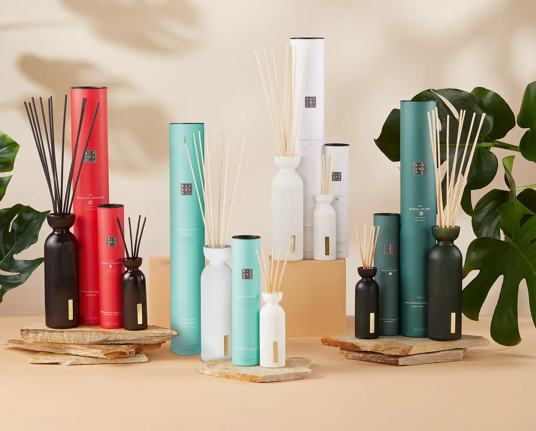 Eine Gruppe von Fragrance Sticks der Marke Rituals mit Pflanzen im Hintergrund, die eine lebendige und natürliche Atmosphäre schaffen.